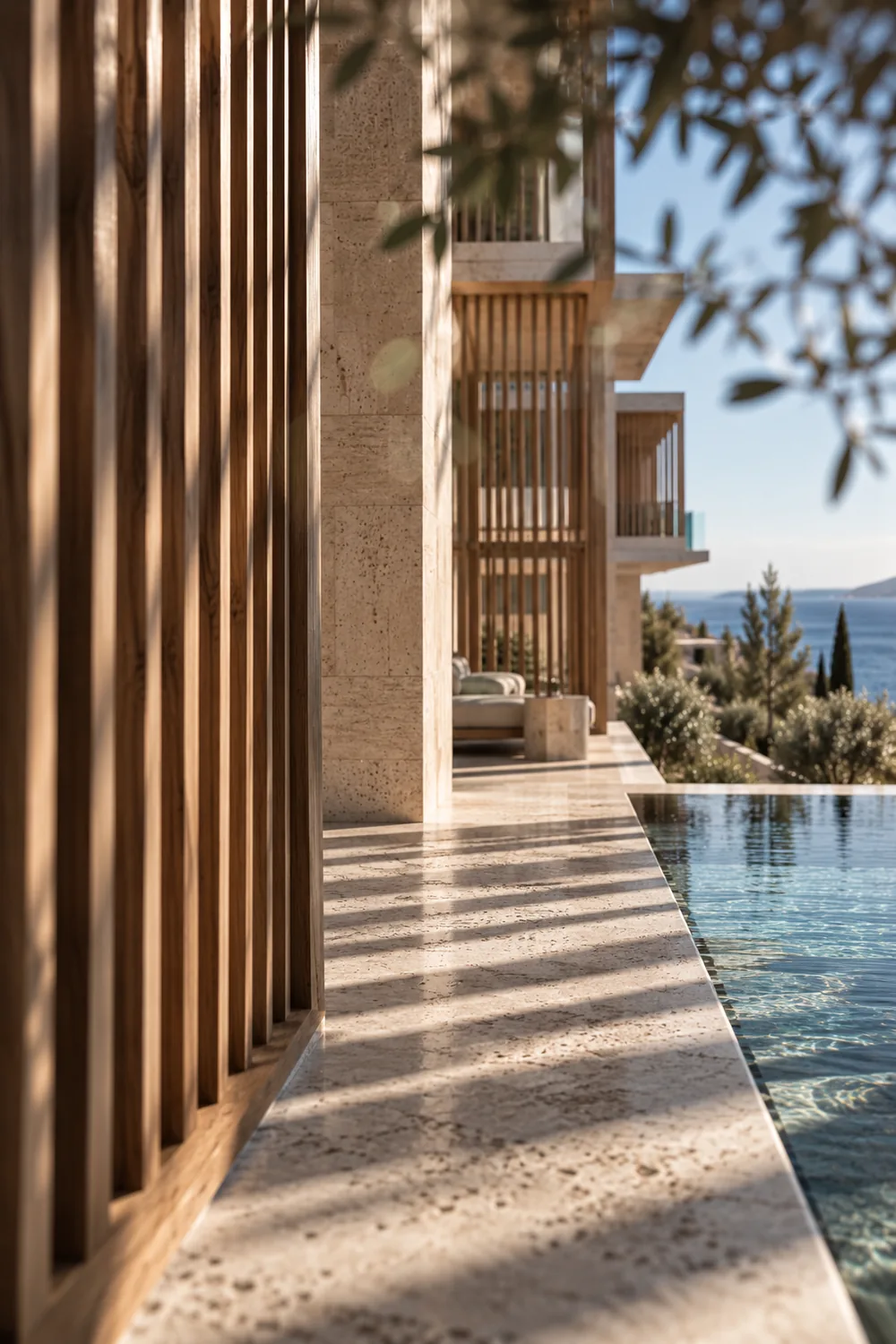Bars of shade from oak louvres along a travertine edge beside the pool.